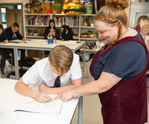 Art teacher helping student with sketching